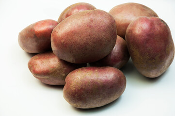 red potatoes on a white background. good harvest concept. ripe potatoes on a light texture	