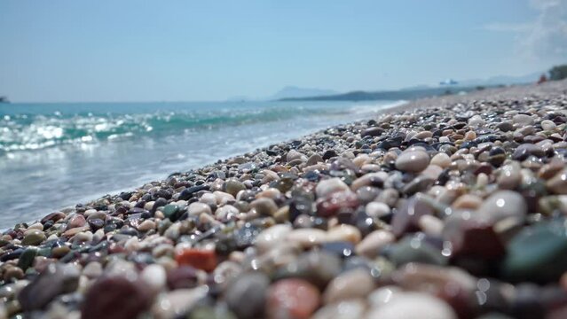 Close-up of sea stones, on the background of sea surf. Sea shore with pebbles.