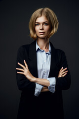 blonde businesswoman looking at camera on black background