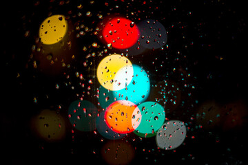 drops on a window with defocused colored lights in the background
