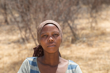 african woman in the village , bush is near by with dry shrubs due to draught