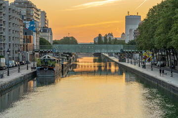 Paris, France - 08 15 2021: Ourcq Canal. Reflections on the Ourcq canal of a bridge, barges and...