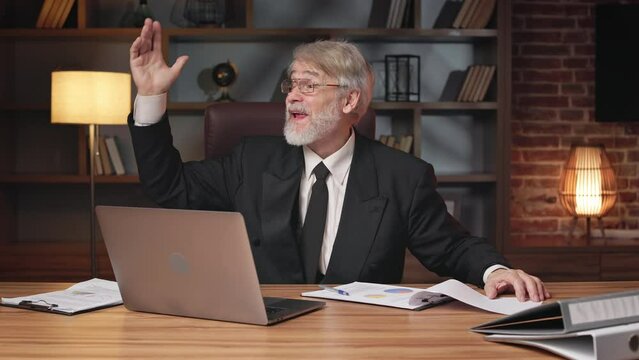 Grey-haired caucasian adult in formal clothes being distracted from paperwork by colleague in meeting room. Experienced manager viewing financial statistic shown in documents via graphical materials.