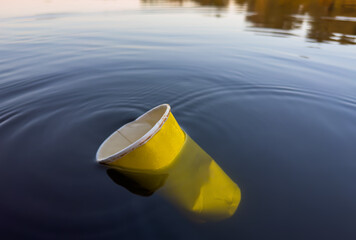 Water pollution. Coffee paper cup Garbage. Marine pollution. Aquatic trash. Paper coffee cup Waste...