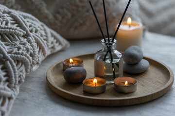 Burning candles, aroma fragrance natural organic diffuser, wooden bamboo tray. Concept of cozy home...
