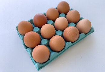 Chicken egg in package on white background. Reusable Egg Carton Is Made from Recycled Materials. 12 eggs in paper pack. Fresh Eggs For Breakfast. Cooking an omelet and scrambled eggs from chicken egg