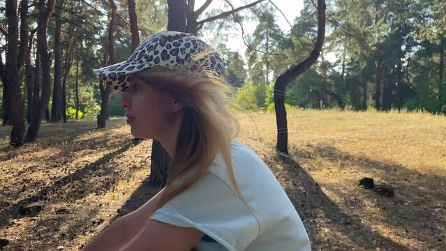 Pensive dreamy happy girl in short breeches and t-shirt riding a bicycle. Woman pedals and looks away in city summer park outdoors. People active urban healthy lifestyle cycling concept. 4k