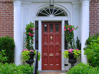 Beautiful wood grain front door of home, surrounded by flowers