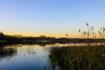 Peaceful landscape with lake in autumn sunset light in Latvia.