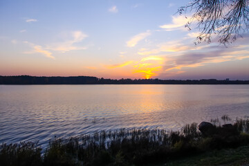 Peaceful landscape with lake in autumn sunset light in Latvia.