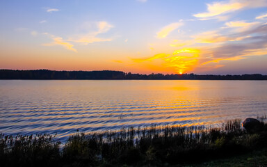 Peaceful landscape with lake in autumn sunset light in Latvia.