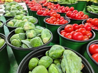 Sprouts and cherry tomatoes in green containers at the farmer's market