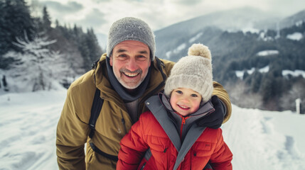 Fototapeta na wymiar Winter portrait of happy father and his kid in snowy mountains.