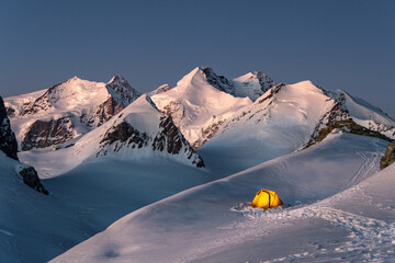 Tenda illuminata circondata dai ghiacciei del Monte Rosa
