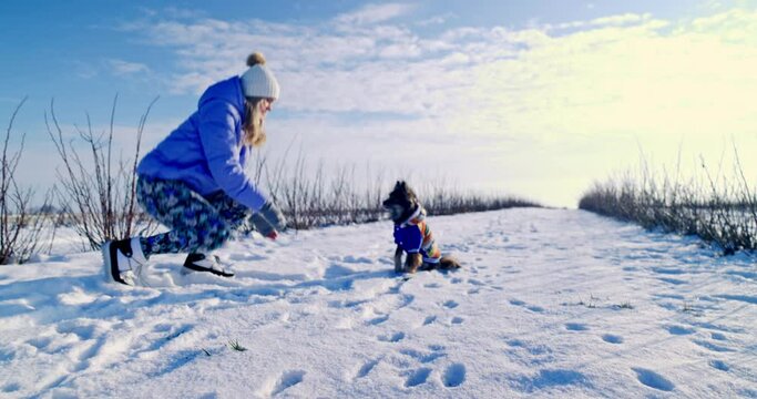 A blonde woman wearing a hat puts on gloves while staying outside.