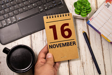 November calendar background with number 16. Stationery pens and pencils in a case on a wooden vintage background.