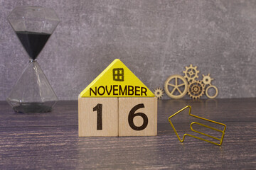 November calendar background with number 16. Stationery pens and pencils in a case on a wooden vintage background.