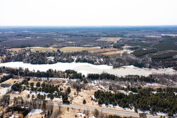 Obraz premium Capture the winter wonder of Barrie, Ontario, Canada, through this stunning drone photograph. Showcasing frozen lakes, dried-out trees, and grass, the image highlights the seasonal beauty of the area