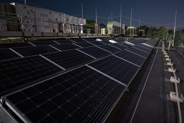 Solar panels in the evening with air conditioning in the background.