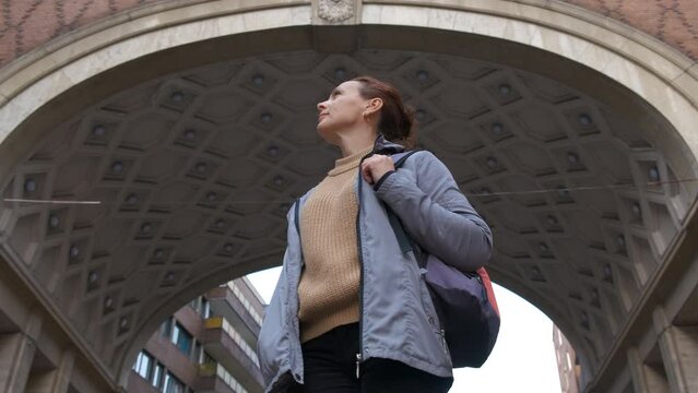 Female tourist enjoy urban facade. A view of female traveler enjoy the brick fasade during day time.