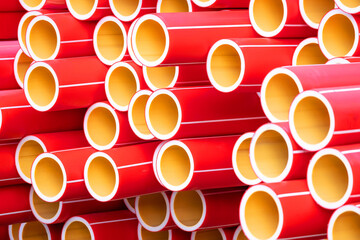 Many red polyethylene or plastic water pipes in a warehouse or construction site. Plumbing...