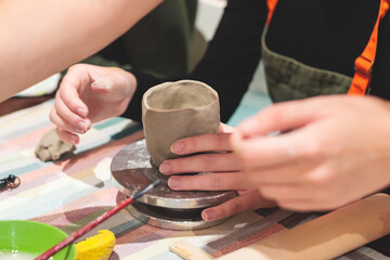Pottery lesson master class for kids children, process of making clay pot on pottery wheel, potter hands creating ceramic crockery handcrafts, ceramist molding and painting jar or vase