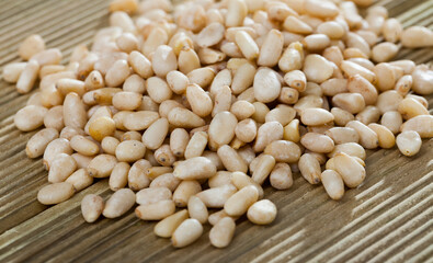 Pile of delicious pine nuts on a wooden surface