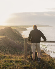 A man looks out to see from a clifftop