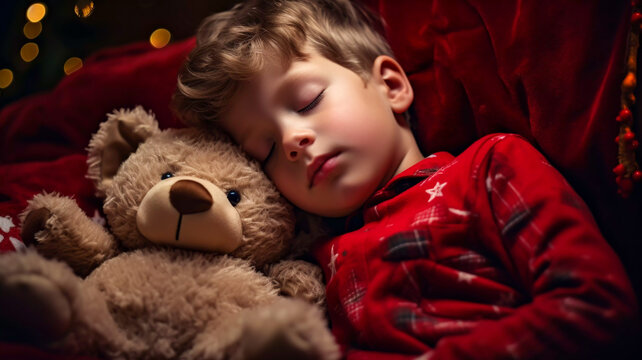 Young boy in red pyjamas fast asleep on Christmas Eve with his teddy bear in front of the Christmas tree Xmas desktop wallpaper