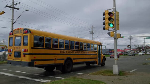 Yellow school bus passes an intersection on a city street.