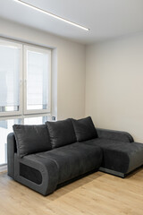 Modern interior of small living room with Smart TV and sofa.