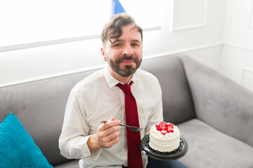 Attractive man celebrating his birthday eating cake