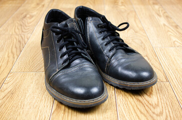 Men's footwear. Black men's boots with laces and a zipper. A pair of men's leather shoes.