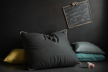 An regular full-size pillow is curled on a dirty black chalkboard. Generative AI