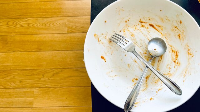 Top view of empty plate, dirty after the meal is finished isolate with clipping path and copy space for text on right area, sauce smeared on a plate.