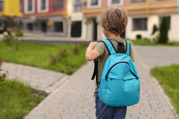 Little boy walking to kindergarten outdoors, back view. Space for text