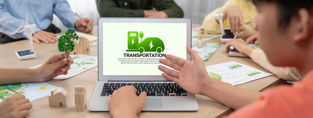 Electric vehicles car sign displayed on green business laptop while business team presenting green...