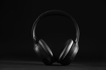 Fototapeta na wymiar Modern wireless headphones on black background, closeup