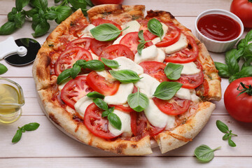 Delicious Caprese pizza with tomatoes, mozzarella and basil on light wooden table