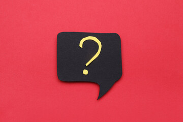 Paper speech bubble with question mark on red background, top view