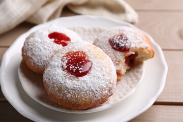 Hanukkah donuts with jelly and powdered sugar on wooden table, closeup
