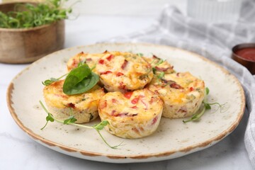 Freshly baked bacon and egg muffins with cheese on table, closeup