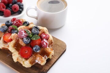 Delicious Belgian waffles with fresh berries on white table, space for text