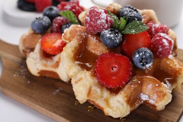 Delicious Belgian waffles with fresh berries served on table, closeup