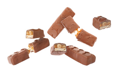 Whole and broken chocolate bars with caramel, nuts and nougat falling on white background