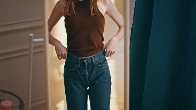 Weight loss female zip jeans closeup. Unhappy woman looking mirror reflection