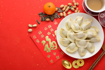 Delicious dumplings on a red background in China. The Chinese meaning in the picture is: attracting wealth and blessings