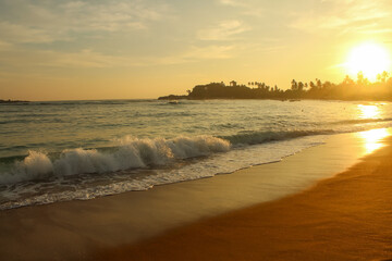 Fototapeta na wymiar Beach with golden sand and blue ocean water on most popular Unawatuna