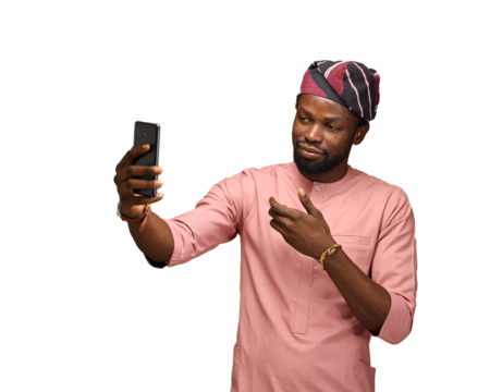 png of a Smiling young African American man guy in top and fila isolated on brown blue wall background. People lifestyle concept. copy space. Doing a selfie shot on a mobile phone showing thumb up