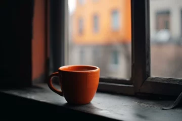 Fotobehang Handmade coffee cup on window sill, urban view outside. Generative AI © Eudoxia